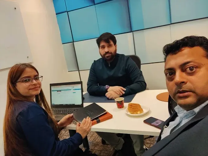 A document discussion around a laptop at our office
