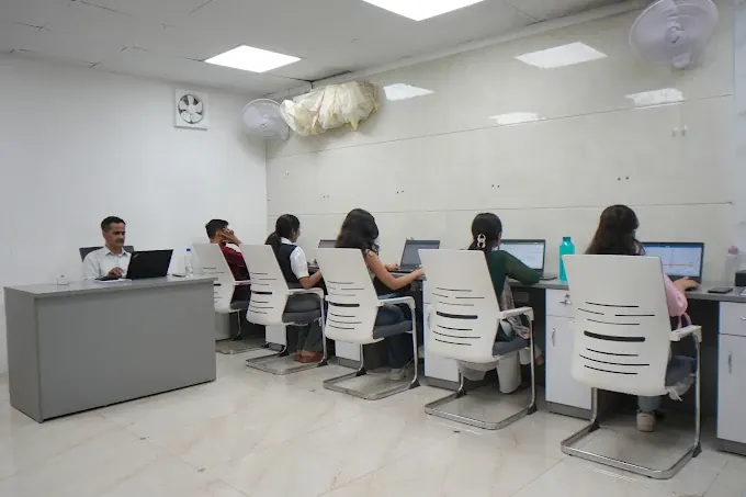 Team members working at white office desks